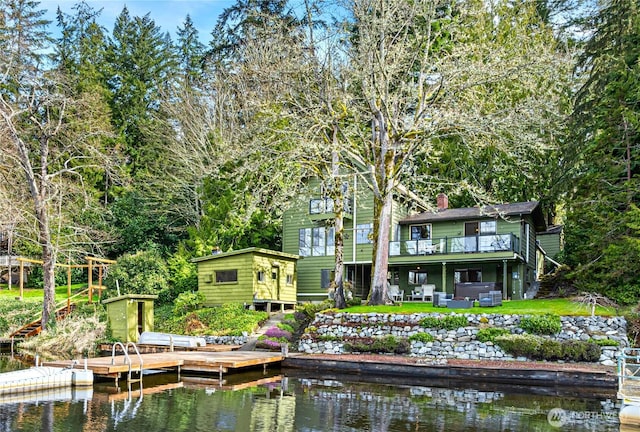 back of property featuring a chimney and a deck with water view