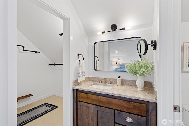 bathroom with baseboards, tile patterned floors, and vanity