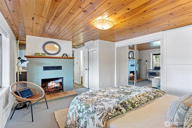 bedroom featuring wooden ceiling, a closet, and a brick fireplace