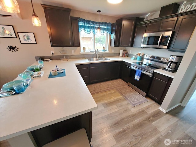 801 340th Pl, Ocean Park, WA 98640 - kitchen featuring a peninsula, dark brown cabinets, light countertops, a sink, and stainless steel appliances