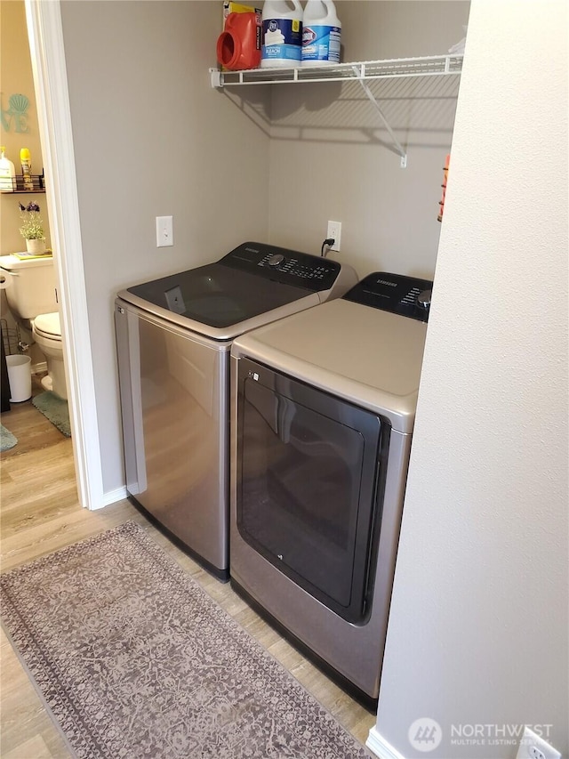 801 340th Pl, Ocean Park, WA 98640 - clothes washing area featuring baseboards, light wood-style floors, washer and clothes dryer, and laundry area