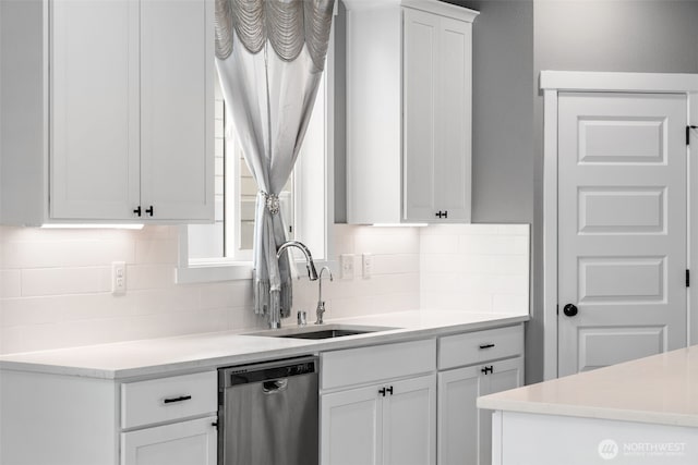 kitchen with dishwasher, white cabinetry, light countertops, and a sink