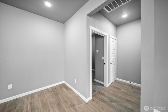 spare room featuring visible vents, recessed lighting, baseboards, and wood finished floors