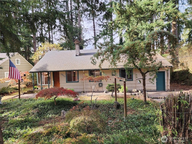 ranch-style house with a chimney and a shingled roof
