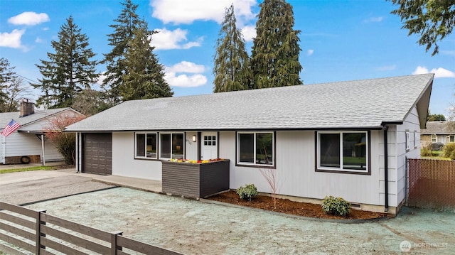 ranch-style house with roof with shingles, concrete driveway, fence, and an attached garage