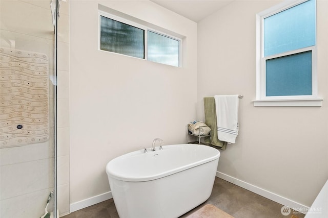 10414 113th Street Ct SW, Lakewood, WA 98498 - full bath featuring a freestanding tub, baseboards, tiled shower, and concrete flooring