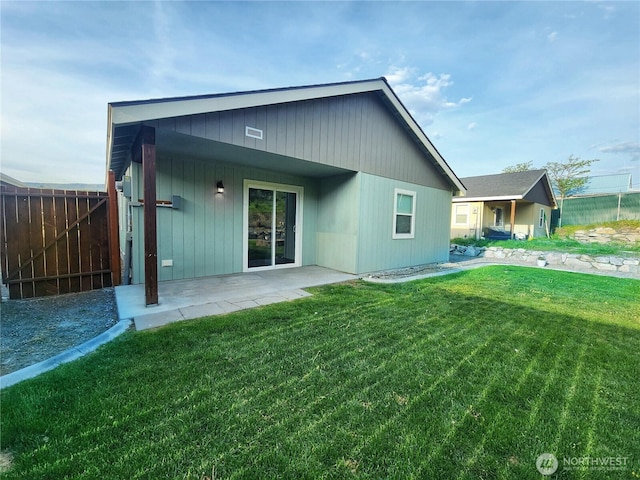 back of house with a lawn, a patio, and fence