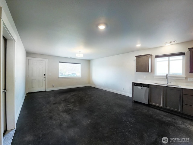 unfurnished living room with plenty of natural light, baseboards, concrete flooring, and a sink