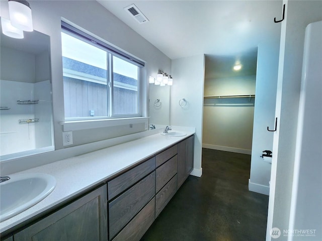 full bathroom featuring visible vents, a spacious closet, concrete floors, and a sink