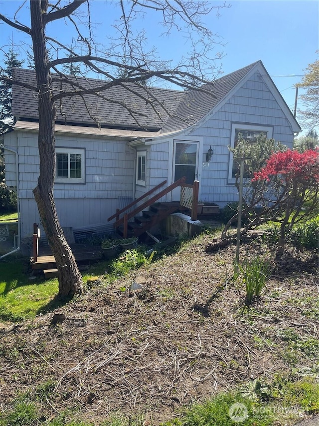 rear view of property with a shingled roof