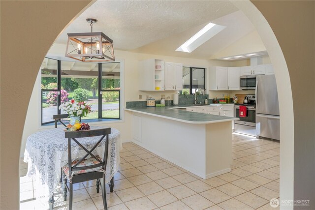 kitchen with white cabinetry, light tile patterned flooring, appliances with stainless steel finishes, and a sink