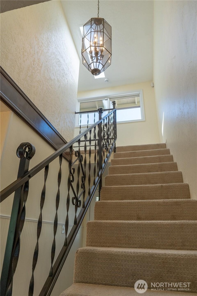 staircase featuring a chandelier
