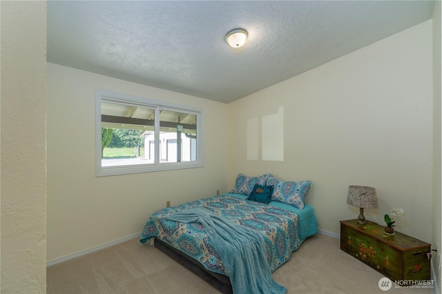 carpeted bedroom featuring baseboards and a textured ceiling