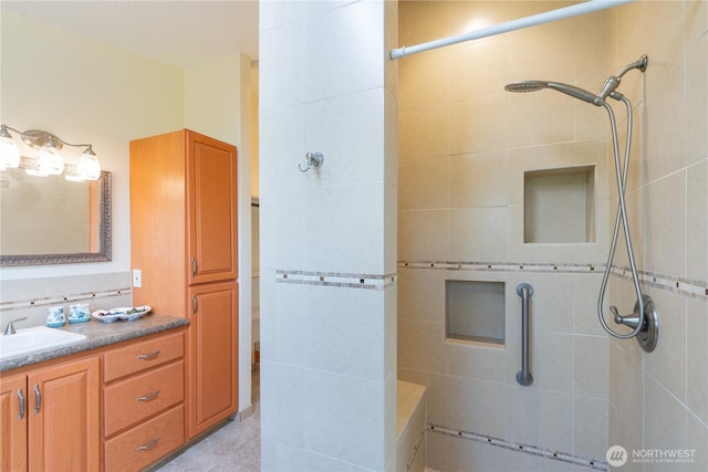full bath featuring vanity and tiled shower