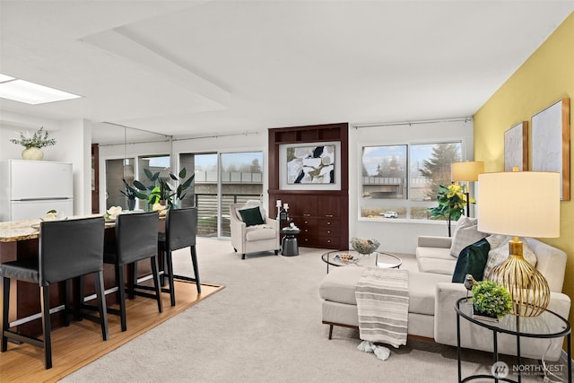 living room featuring light carpet and a skylight