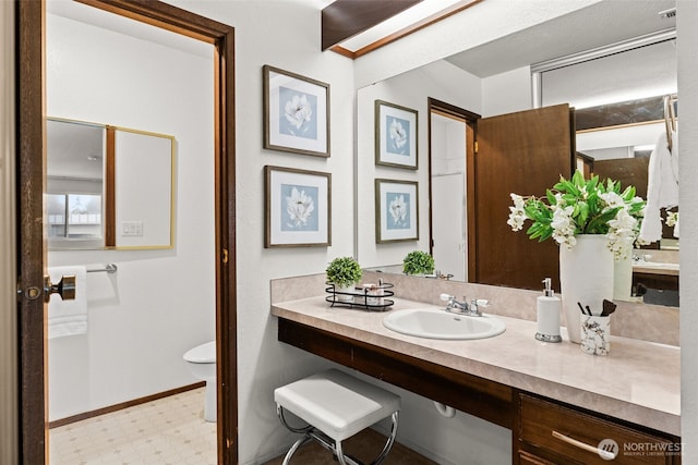 bathroom with vanity, tile patterned floors, toilet, and baseboards