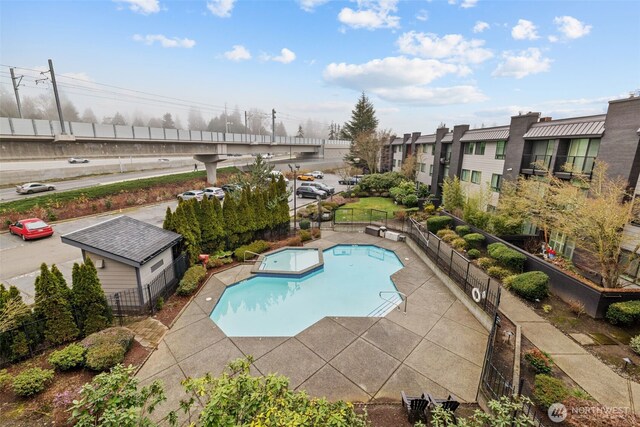 pool with a patio and fence