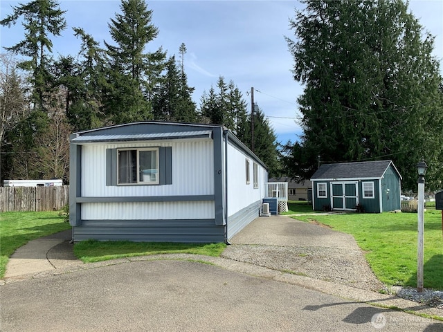 302 Pioneer Rd, Aberdeen, WA 98520 - manufactured / mobile home with an outdoor structure, asphalt driveway, and a metal roof
