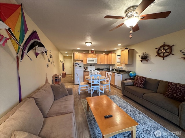 living area with wood finished floors, recessed lighting, a textured ceiling, and ceiling fan