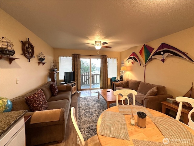 living room with wood finished floors, a textured ceiling, and ceiling fan