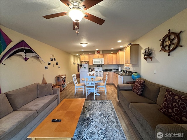 living room featuring a textured ceiling, recessed lighting, light wood-style floors, and a ceiling fan