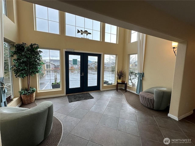 foyer entrance featuring baseboards, a wealth of natural light, french doors, and tile patterned flooring