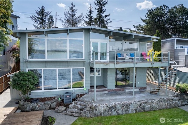 rear view of property with central air condition unit, a patio, a sunroom, and a balcony