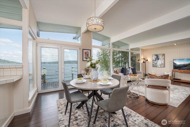 dining space featuring a healthy amount of sunlight, beamed ceiling, and dark wood finished floors