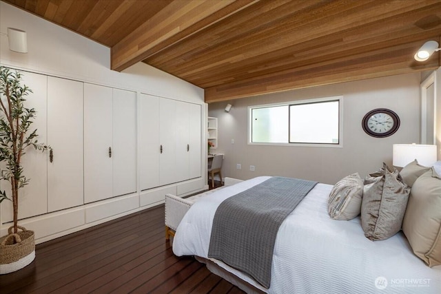 bedroom with two closets, lofted ceiling with beams, dark wood finished floors, and wooden ceiling