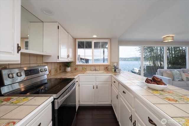 kitchen with tile counters, a sink, and stainless steel electric range