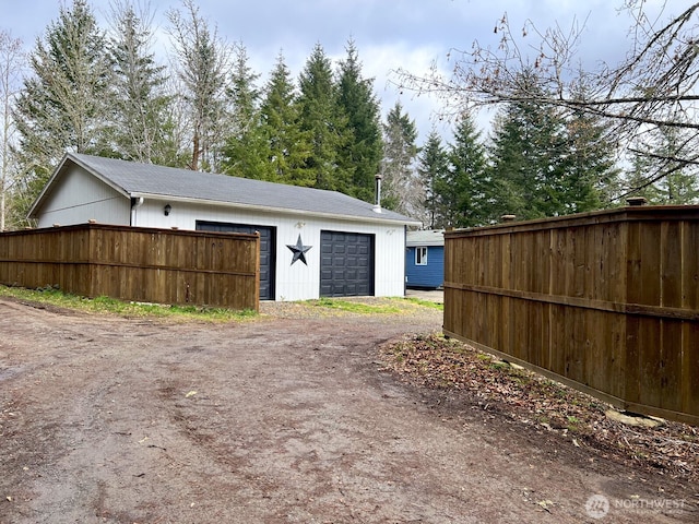 garage with driveway and fence