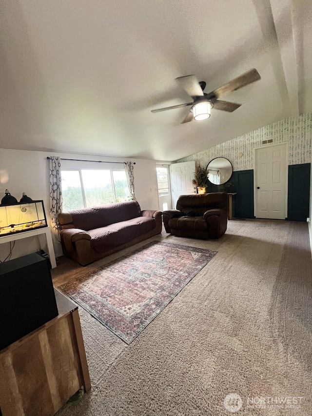 living room featuring visible vents, a textured ceiling, carpet, wallpapered walls, and ceiling fan