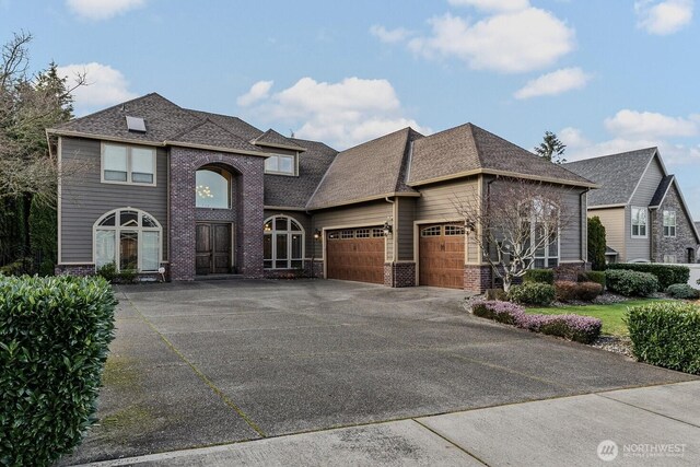 view of front of house featuring driveway, an attached garage, brick siding, and roof with shingles