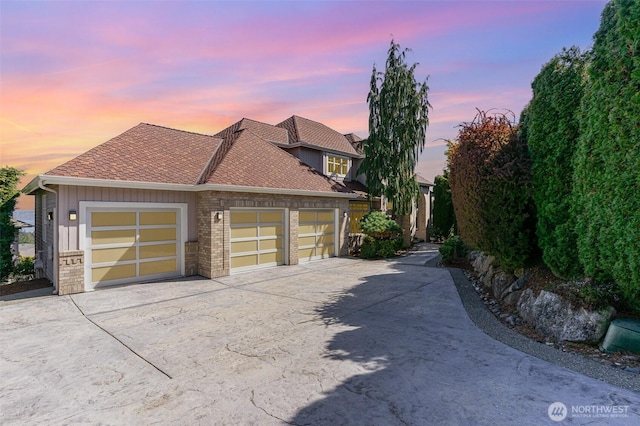 15832 SE 45th St, Bellevue, WA 98006 - property exterior at dusk with concrete driveway, an attached garage, brick siding, and a shingled roof