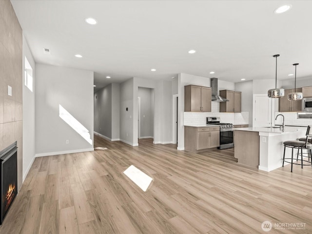 11521 SE 236th St, Kent, WA 98031 - unfurnished living room with a sink, a fireplace, recessed lighting, light wood-style flooring, and baseboards