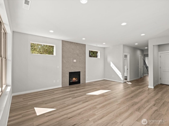 11521 SE 236th St, Kent, WA 98031 - unfurnished living room with recessed lighting, light wood-type flooring, baseboards, a tiled fireplace, and stairway