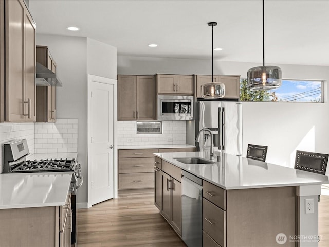 11521 SE 236th St, Kent, WA 98031 - kitchen featuring stainless steel appliances, a sink, under cabinet range hood, light countertops, and wood finished floors