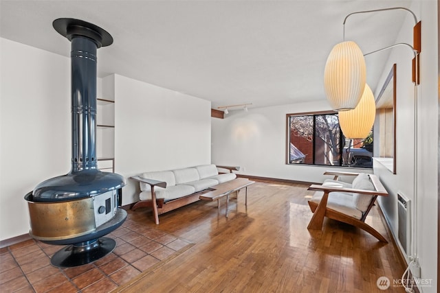 living area featuring rail lighting, baseboards, and wood finished floors