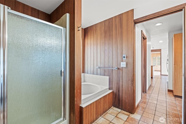 bathroom featuring a bath, wood walls, a shower stall, recessed lighting, and tile patterned flooring