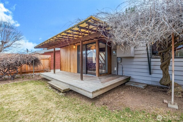 wooden deck featuring a pergola, fence, and a yard