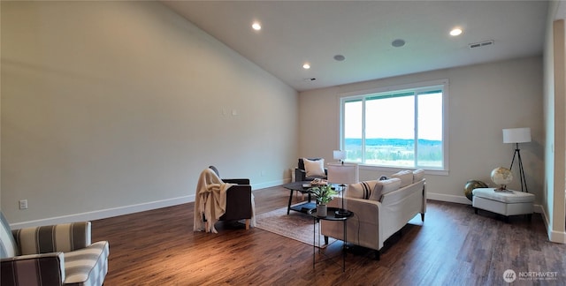 living room with baseboards, visible vents, vaulted ceiling, and dark wood finished floors