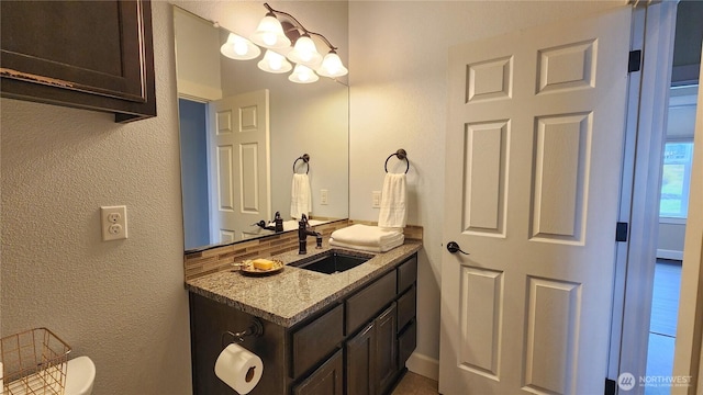 bathroom featuring a textured wall and vanity