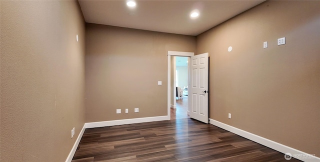 empty room with dark wood-style floors, recessed lighting, and baseboards