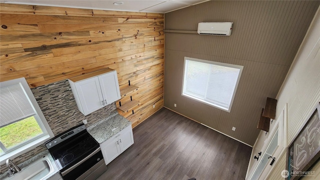 unfurnished living room featuring dark wood finished floors, a wall unit AC, and a sink