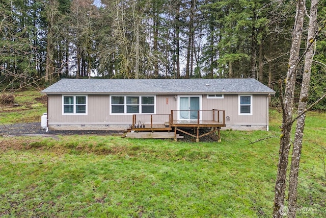 view of front of property featuring a front lawn, crawl space, a deck, and roof with shingles