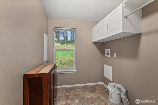 clothes washing area with cabinet space, stone finish flooring, baseboards, and washer hookup