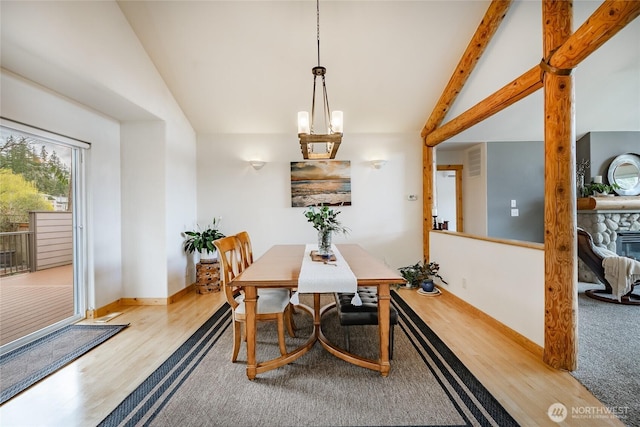 2932 Huntington St, Bellingham, WA 98226 - dining space with a notable chandelier, a stone fireplace, visible vents, vaulted ceiling with beams, and wood finished floors