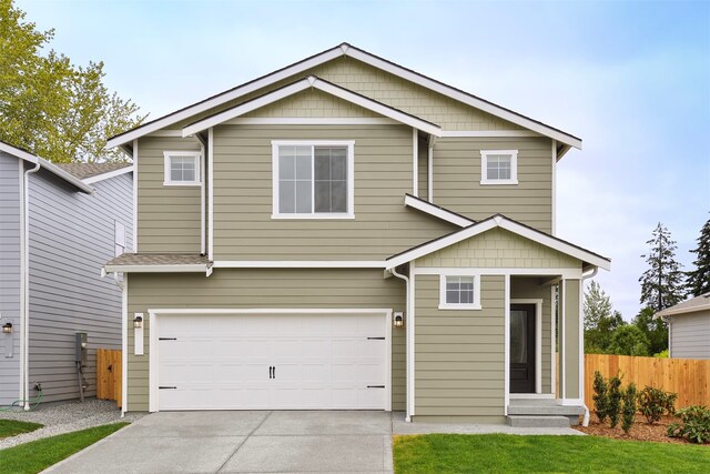 view of front of home with driveway, fence, and an attached garage