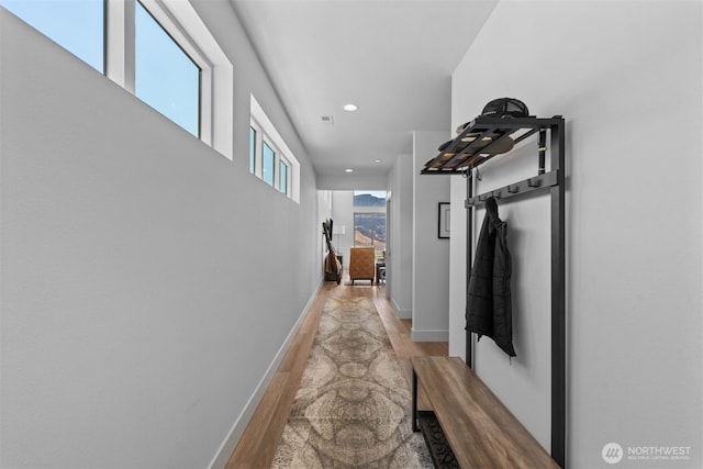 hall with recessed lighting, light wood-type flooring, and baseboards
