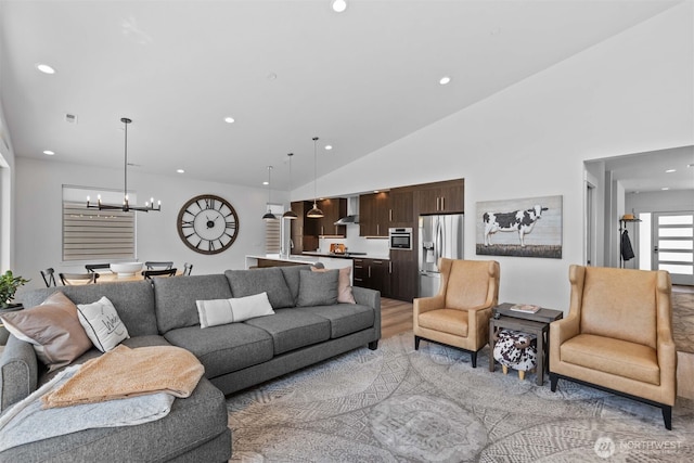 living room featuring a chandelier, high vaulted ceiling, light wood-style flooring, and recessed lighting